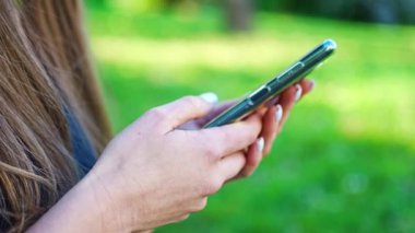 Spor yapmadan önce akıllı telefon kullanan genç bir kadının ellerine yakından bakın. Spor, teknoloji ve sağlıklı yaşam tarzı konsepti. Yüksek kalite 4k görüntü