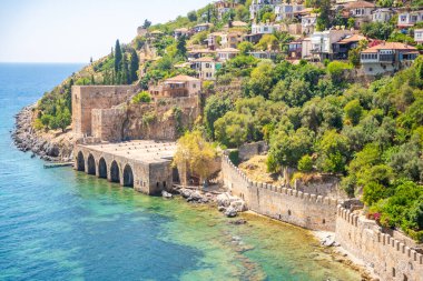 Türkiye 'nin Alanya kentindeki Kizil Kule kulesi yakınlarındaki antik tersane veya Tersane ve güzel plaj ve sakin turkuaz deniz yüzeyi. Yüksek kalite fotoğraf