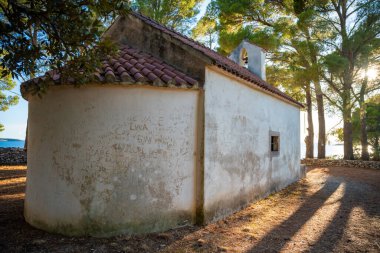 Hırvatistan 'ın Uvala Gradina kenti - 5 Temmuz 2024: Hırvatistan' ın Korcula adasındaki Vela Luka kasabası yakınlarındaki Uvala Gradina körfezinde Aziz İvan veya John Church. Yüksek kalite fotoğraf