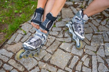 Patenci kadının paten kayışını yakından görebiliyoruz. Parkta paten kayarken. Açık hava aktiviteleri. Yaz pateni. Yüksek kalite fotoğraf