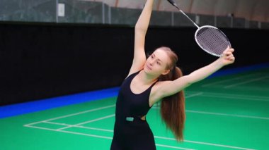Raket ve mekik aletli genç bayan badminton oynamadan önce antrenman yapıyor, ısınıyor. Yüksek kalite 4k görüntü