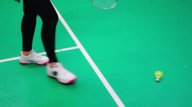 Raketli genç bayan, badminton oynarken badminton yapıyor. Sahada. Yüksek kalite 4k görüntü