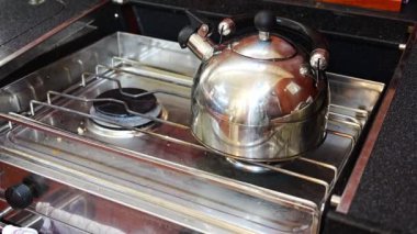 Yat gezisi sırasında yatta ısıtılan gaz ocağındaki su ısıtıcısı. Yüksek kalite 4k görüntü
