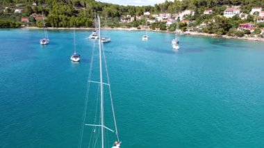Hırvatistan 'ın Korcula adasındaki Vela Luka kasabası yakınlarındaki Uvala Gradina körfezindeki şamandıralara demirlemiş yatların insansız hava aracı görüntüsü. Yüksek kalite 4k görüntü