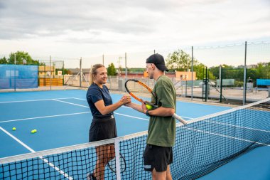 Profesyonel tenisçiler dışarıda tenis maçının sonunda el sıkışıyor. Yüksek kalite fotoğraf