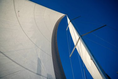 Güneş ışığında denizde yelken açan yelkenli bir yatın yelkenleri. Yüksek kalite fotoğraf