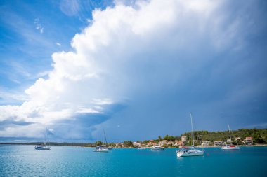 Yachts moored on buoys near the shore in the bay of Uvala Gradina near the town of Vela Luka on the island of Korcula in Croatia. High quality photo clipart