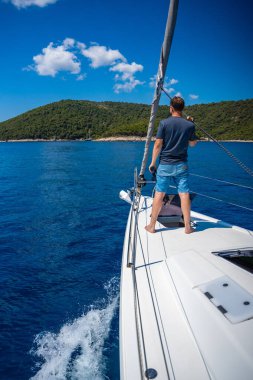 Yelkenli teknede dürbünle bakan genç bir kaptan. Seyahat ve aktif hayat. Yatçılık. Yüksek kalite fotoğraf