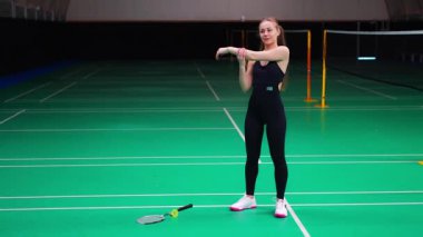 Raket ve mekik aletli genç bayan badminton oynamadan önce antrenman yapıyor, ısınıyor. Yüksek kalite 4k görüntü