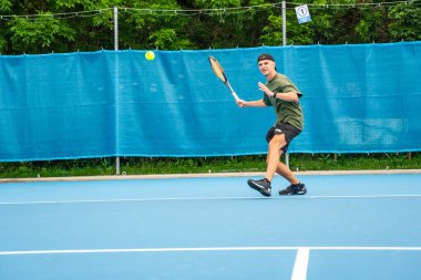 Saha dışında tenis oynayan profesyonel erkek tenisçi. Yüksek kalite fotoğraf