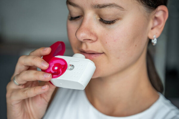 Крупный план женщины, использующей ингалятор сухого порошка для лечения астмы или ХОБЛ заболеваний. Фармацевтический препарат используется для лечения воспаления легких и предотвращения приступа астмы. Высокое качество фото