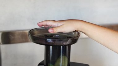 Ev mutfağında taze meyve suyu ya da meyve suyu hazırlayan küçük kızı yakından izleyin. Yüksek kalite 4k görüntü