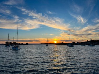 Hırvatistan 'ın gün batımında Korcula adasındaki Vela Luka kasabası yakınlarındaki Uvala Gradina körfezi yakınlarındaki şamandıralara demirlemiş yatlar. 