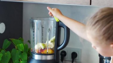 Küçük kız evde taze meyveli meyve suyu ya da smoothie hazırlıyor. Yüksek kalite 4k görüntü