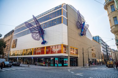 Praha, Czech republic - August 28, 2024: Shopping centre Maj on National avenue street with air-plane sculpture butterfly wings by David Cerny. Socialist mall after reconstruction. clipart