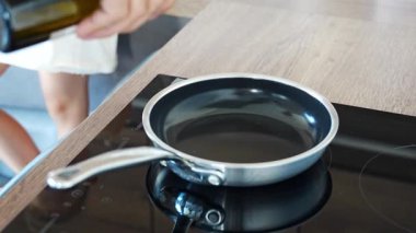 Yağ önceden ısıtılmış bir tavaya dökülür ve pişirme işlemi sırasında yüzeyine yayılır. Aile yemeği. Yüksek kalite 4k görüntü