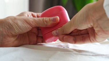 Kadın eli ve çocuk eşyaları imzalamak için damgalı kadın eli yakın çekim görüntüsü. Kişisel kıyafetlerin kimliği. Yüksek kalite 4k görüntü