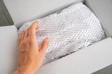 Kurye teslimat servisinin getirdiği malların paketlendiği, çevresel ambalaj konsepti olan güvenli taşımacılık için oyulmuş beyaz kağıt. Yüksek kalite fotoğraf