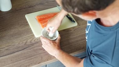 Somon balığı hazırlamak için baharat ve kurutulmuş otlar öğüten bir adam. Yüksek kalite 4k görüntü