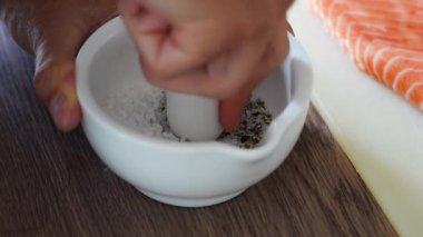 Somon balığı hazırlamak için baharat ve kurutulmuş otlar öğüten bir adam. Yüksek kalite 4k görüntü