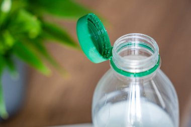 PET şişesinde durgun plastik kapak. Yeni tasarım, kapağın açıldıktan sonra şişeye bağlı kalması ve tüm paketin toplanıp geri dönüşümünün kolaylaştırılması anlamına geliyor. Yüksek kalite fotoğraf