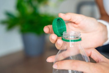 PET şişesinde durgun plastik kapak. Yeni tasarım, kapağın açıldıktan sonra şişeye bağlı kalması ve tüm paketin toplanıp geri dönüşümünün kolaylaştırılması anlamına geliyor. Yüksek kalite fotoğraf