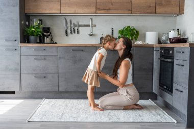 Anne ve kızı mutfakta oturup birlikte vakit geçiriyorlar. Aile bağı. Yüksek kalite fotoğraf