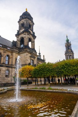 Dresden, Almanya - 19 Ekim 2024: Dresden, Almanya 'nın tarihi merkezinde fontain yakınlarında yürüyen turistler. 