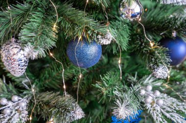 Mavi ve gümüş oyuncaklı Noel ağacı. Şenlikli Noel ağacı çelenklerle süslenmiş. Yeni yılın moda renklerinde sembolü. Yüksek kalite fotoğraf