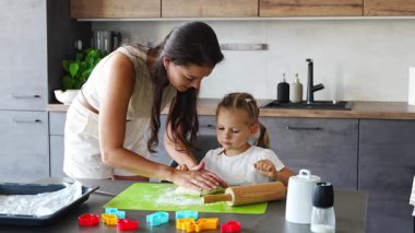 Genç anne ve kızı mutfakta kurabiye için para kazanıyorlar. Ev mutfağında mutlu bir aile. Yüksek kalite 4k görüntü