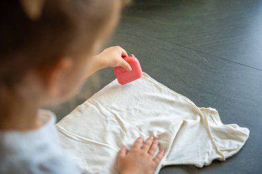 Çocukça şeyler imzalayan damgalı küçük bir kızın arka plan görüntüsü. Kişisel kıyafetlerin kimliği. Yüksek kalite fotoğraf