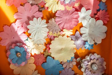 Arkaplan olarak 3 boyutlu çiçeklerin yaratıcılığı için küçük, renkli kağıt çiçekler. Çocuk geliştirme oyuncağı. Yüksek kalite fotoğraf