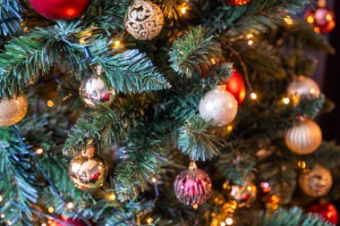 Kırmızı, altın ve gümüş oyuncaklı Noel ağacı. Şenlikli Noel ağacı çelenklerle süslenmiş. Yeni yılın moda renklerinde sembolü. Yüksek kalite fotoğraf
