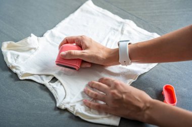 Kadın eli ve çocuk eşyaları imzalamak için damgalı kadın eli yakın çekim görüntüsü. Kişisel kıyafetlerin kimliği. Yüksek kalite fotoğraf