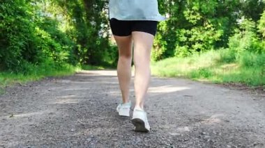 Yaz parkında genç bayan koşucu eğitimi. Spor salonundaki kadın dışarıda koşuyor. Sabah koşusu kavramı. Yüksek kalite 4k görüntü