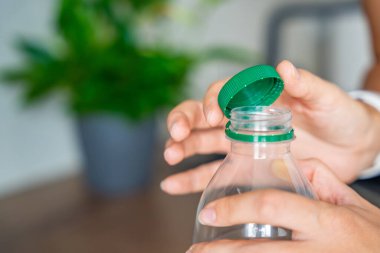 PET şişesinde durgun plastik kapak. Yeni tasarım, kapağın açıldıktan sonra şişeye bağlı kalması ve tüm paketin toplanıp geri dönüşümünün kolaylaştırılması anlamına geliyor. Yüksek kalite fotoğraf