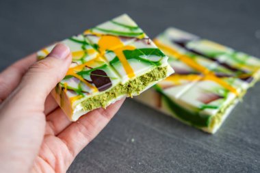 Moda eseri Dubai beyaz çikolatası şam fıstığı ezmesi ve kadın elinde kataifi hamuru. Evde, mutfakta el yapımı şekerlemeler var. Yüksek kalite fotoğraf