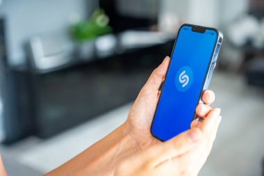 Prag, Çek Cumhuriyeti - 2 Mayıs 2024: Mobil uygulama uygulamasıyla ekranda Shazam uygulamasının logosu olan iPhone 'u tutan kadın. Yüksek kalite fotoğraf