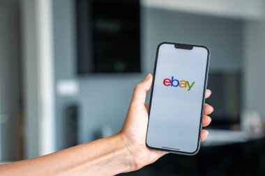 Prag, Çek Cumhuriyeti - 2 Mayıs 2024: Mobil uygulama uygulaması Ebay ekranında iPhone 'u elinde tutan kadın. Yüksek kalite fotoğraf