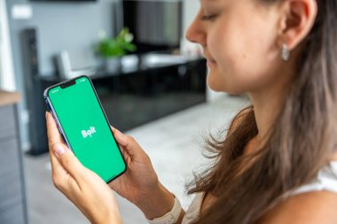 Prag, Çek Cumhuriyeti - 2 Mayıs 2024: Mobil uygulama uygulamasıyla ekranda Bolt uygulamasının logosunun bulunduğu iPhone 'u tutan kadın. Yüksek kalite fotoğraf