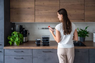 Kilo kaybı için sağlıklı beslenme planı olan genç bir kadın, günlük hazır yemek menüsü teslimatı. Cep telefonu uygulaması ile sipariş edilen yemek. Tabakla dengeli porsiyon. Pişirme öncesi. Yüksek kalite fotoğraf