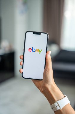 Prag, Çek Cumhuriyeti - 2 Mayıs 2024: Mobil uygulama uygulaması Ebay ekranında iPhone 'u elinde tutan kadın. Yüksek kalite fotoğraf