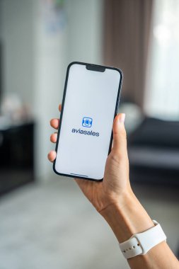 Prag, Çek Cumhuriyeti - 2 Mayıs 2024: Mobil uygulama uygulaması olan Aviasales 'i ekranda elinde tutan kadın. Yüksek kalite fotoğraf