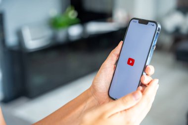 Prag, Çek Cumhuriyeti - 2 Mayıs 2024: İş yeri için mobil uygulama kullanarak ekranda YouTube uygulaması logolu iPhone tutan kadın. Yüksek kalite fotoğraf