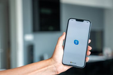 Prag, Çek Cumhuriyeti - 2 Mayıs 2024: İş yeri için mobil uygulama kullanan, ekranda uygulama logosu olan iPhone 'u tutan kadın. Yüksek kalite fotoğraf