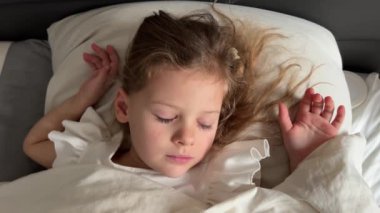 Evdeki yatağında uyuyan tatlı küçük kız, şekerleme konsepti. Yüksek kalite 4k görüntü