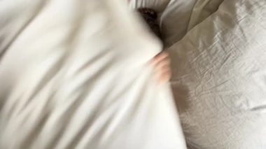 Küçük kız rahat bir yatakta eğleniyor. Aktif çocuk evde eğleniyor, taşınmaktan hoşlanıyor. Yüksek kalite 4k görüntü