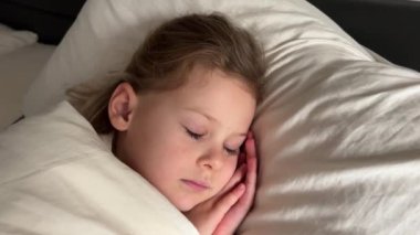 Evdeki yatağında uyuyan tatlı küçük kız, şekerleme konsepti. Yüksek kalite 4k görüntü