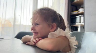 Küçük kız dizüstü bilgisayarlarda çizgi film izliyor ve gülüyor. Yüksek kalite 4k görüntü
