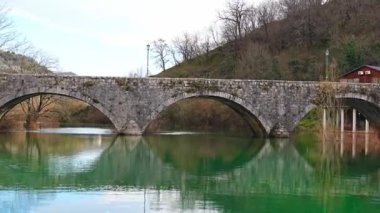 Karadağ 'ın Skadar Gölü yakınlarındaki Crnojeviç Nehri üzerindeki kemerli köprünün altından görüntüler. Yüksek kalite 4k görüntü